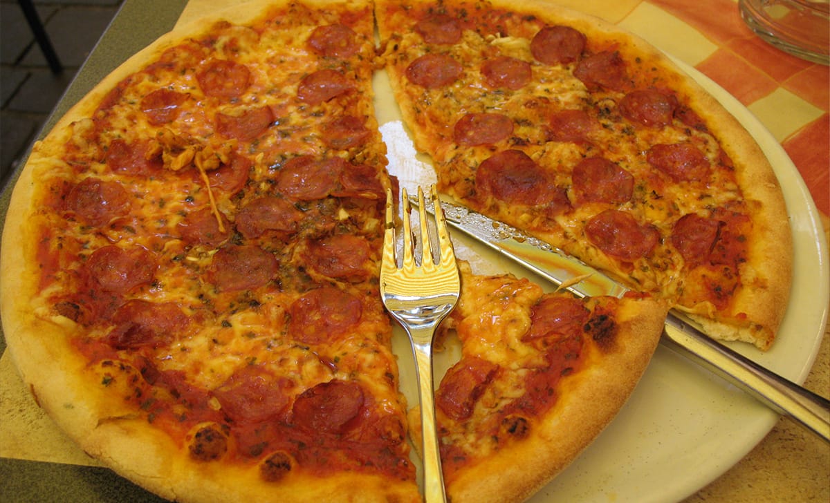 mangiare la pizza usando coltello e forchetta