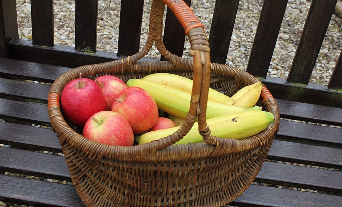 una cesta di banane e mele