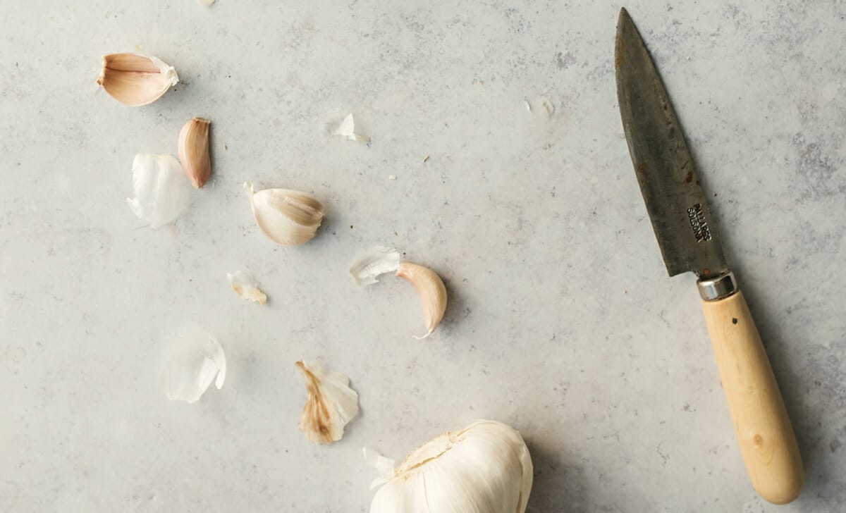 Un modo molto veloce e pratico per sbucciare l'aglio è con un coltello a lama piatta